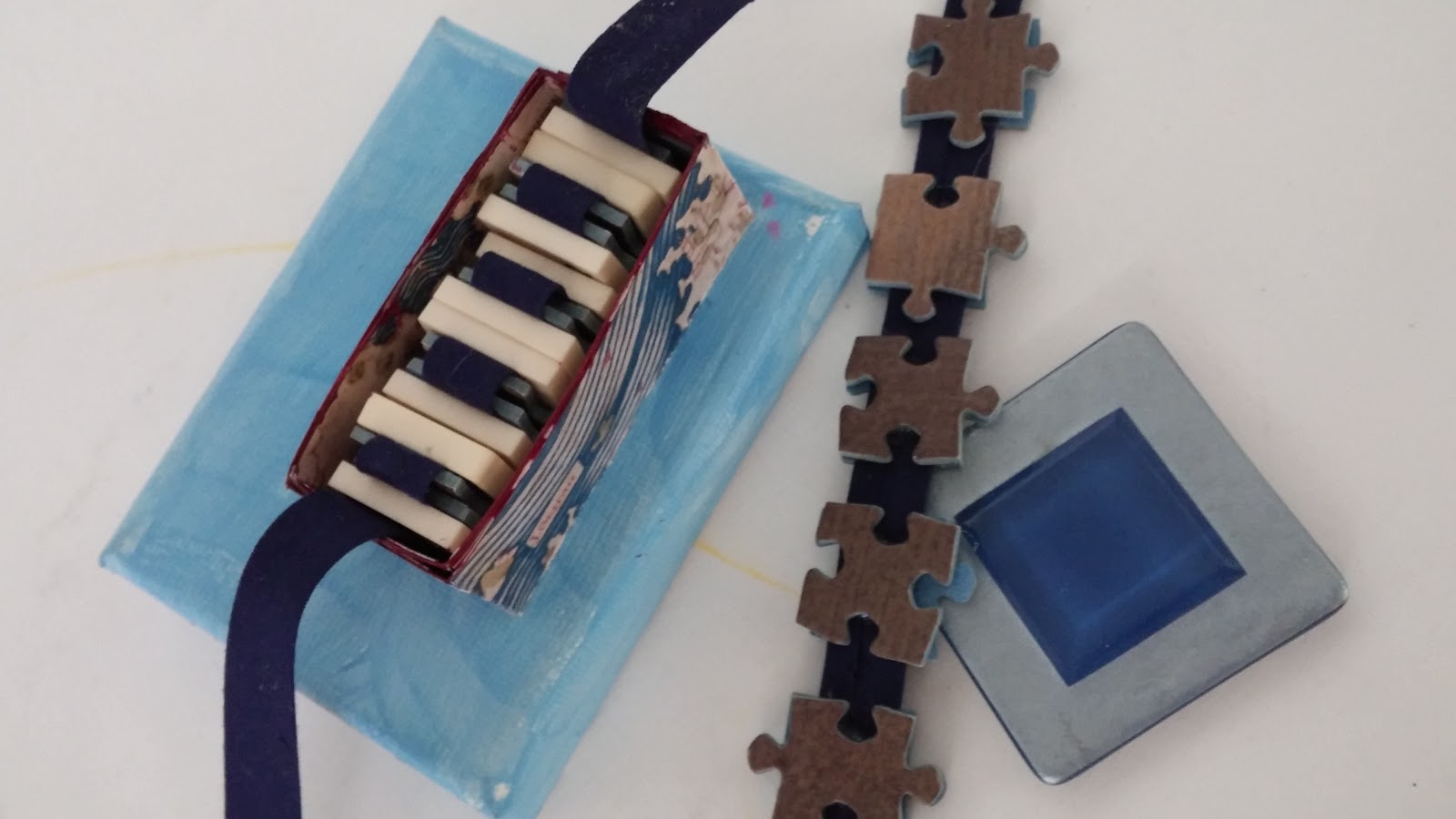 Concertinas from jigsaw pieces and scrabble tiles on bias binding